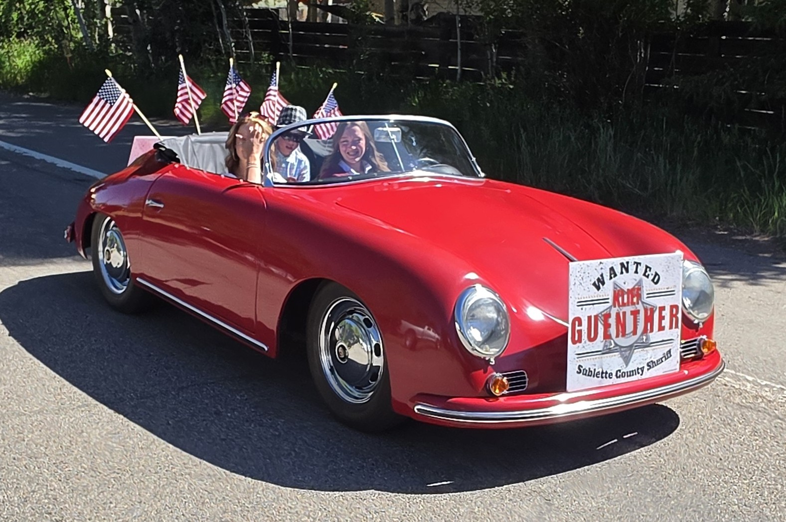 Klief's family riding in a classic red convertible with American flags at the Green River Rendezvous Parade